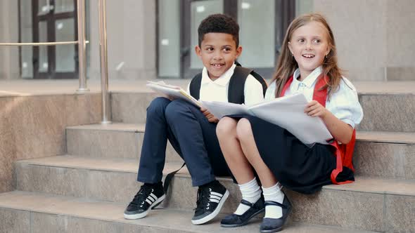 School Children Reading Book While Sitting on Stairs