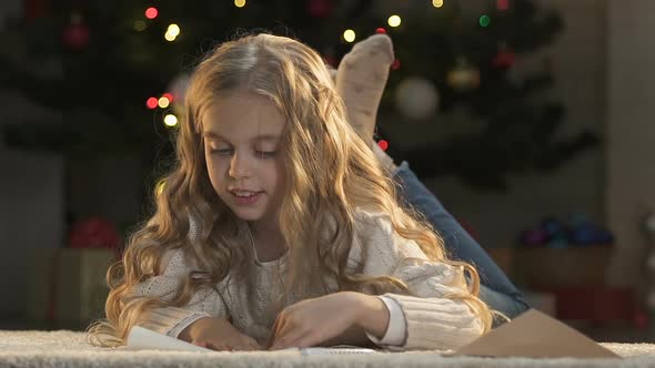 Little Girl Putting Letter to Santa Into Envelope, Faith in Christmas Miracle