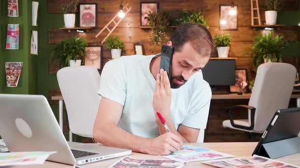 Young Content Creator Talking on the Phone and Writing Notes