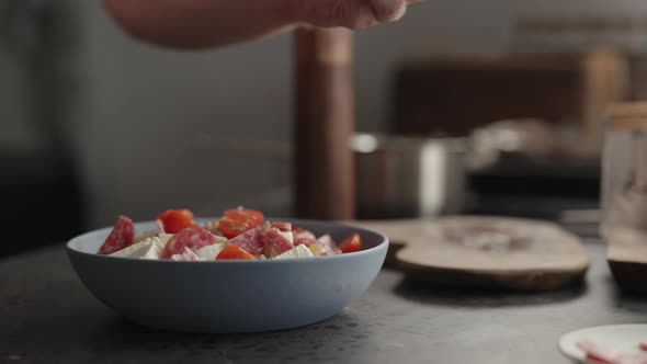 Slow Motion Add Cherry Tomatoes to Fusilli Pasta in Blue Bowl