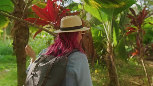 Outdoors Summer Adventure Woman with Backpack Walking By Tropical Jungle Forest