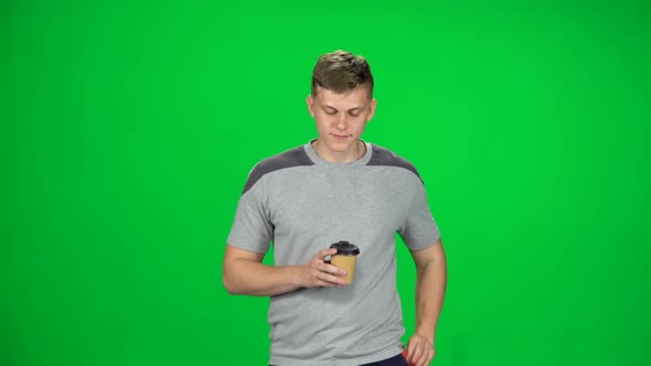 Young Man Walking and Watching on the Phone Something, Drinking Coffee, Chroma Key, Slow Motion