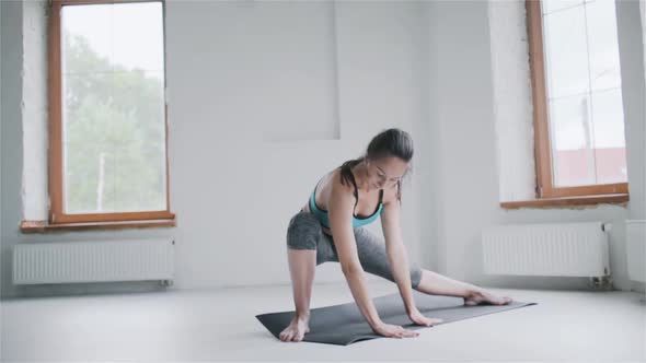 Young Sporty Brunette Girl in Sportswear Does Exercises in Bright Room at Home