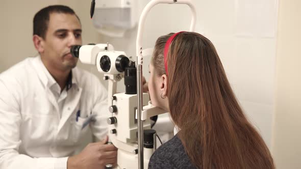 a Teenager Fixes Head on a Pedestal in Clinic of an Oculist To Check His Vision