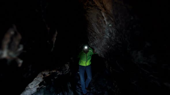Male hiker exploring a dark cave 4k