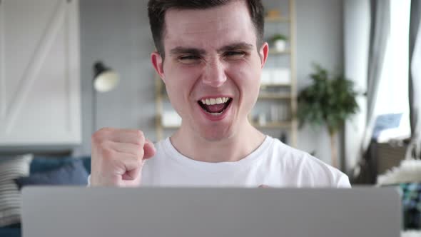 Excited Man Celebrating Success on Laptop
