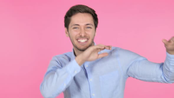 Happy Young Man Dancing on Pink Background