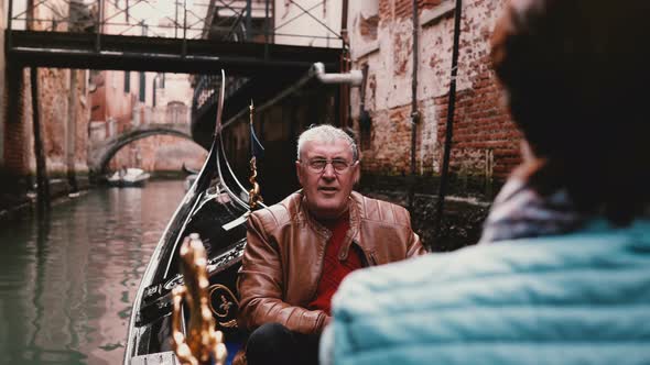 Happy Smiling Senior European Man and Woman in Gondola Enjoying Venice Canal Tour Excursion on