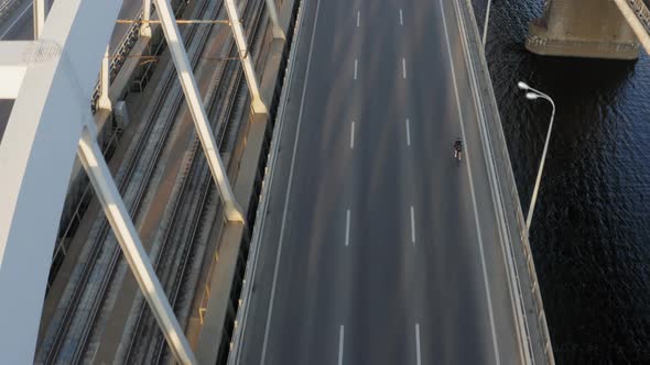 Aerial drone view of cyclist riding over the bridge