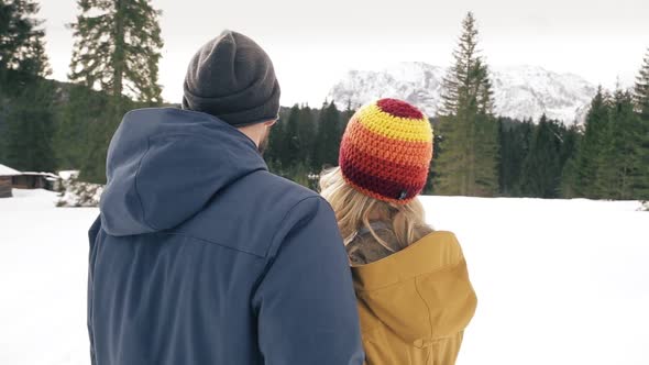 Couple in love during a walk in winter, looking at camera