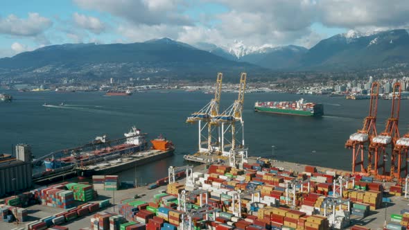 Aerial view over Vancouver Harbour as a large container ship leaves port.