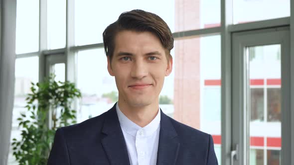 Handsome european man with trendy hairdo studio background. Cheerful guy smiling