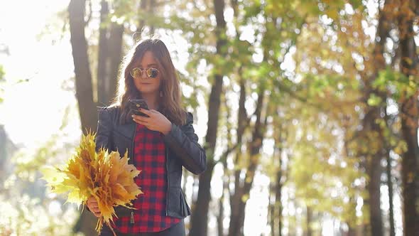Beautiful teenage girl taking Selfie on smartphone outdoors in Park on Sunny autumn day