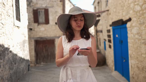 Millennial Caucasian Tourist Scrolling Smartphone Screen in Slow Motion Looking Around Standing in