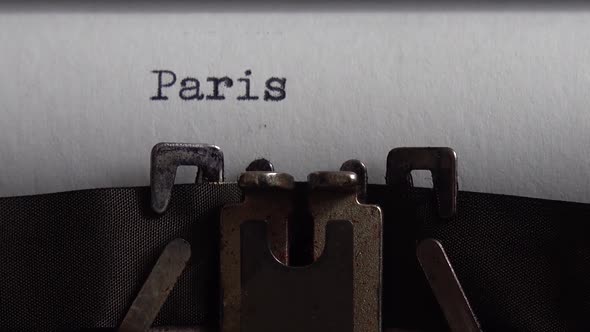 Typing city name Paris on an old typewriter. Close up.