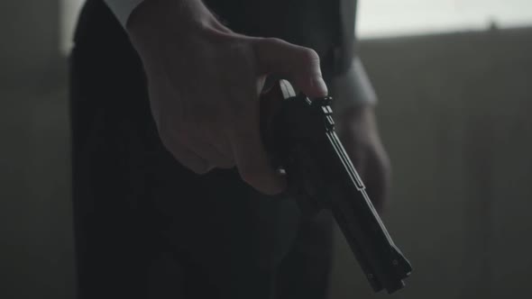 Close Up of a Male in Formal Suit with a Gun in Hand