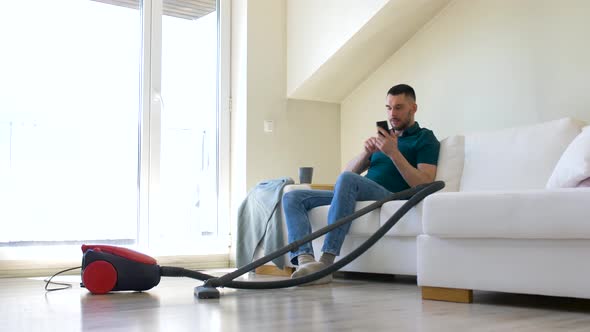 Man Calling on Smartphone After Home Cleaning 