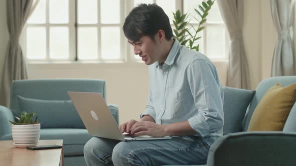 Male Using Laptop In Living Room