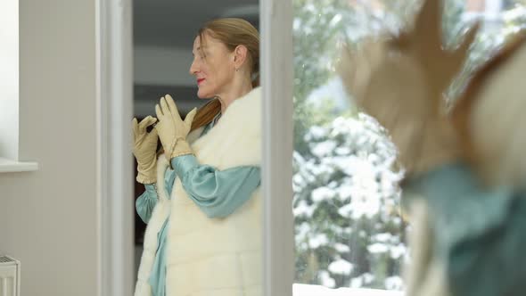 Reflection in Mirror of Stylish Confident Satisfied Wealthy Woman Putting on Ring on Glove