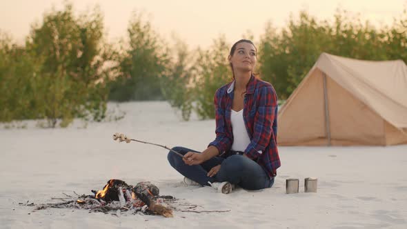 Tourist Woman Camping Near Campfire Outdoors on the Nature