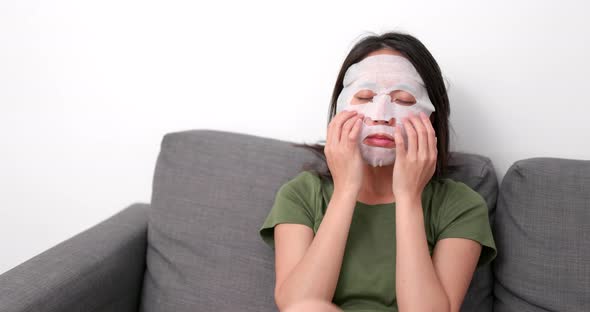 Woman apply skincare mask on face at home