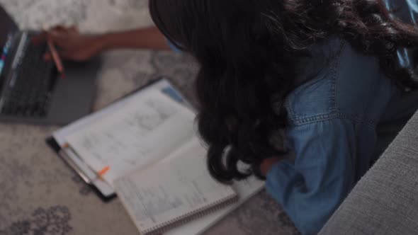 Overhead view of African woman working with laptop on the floor