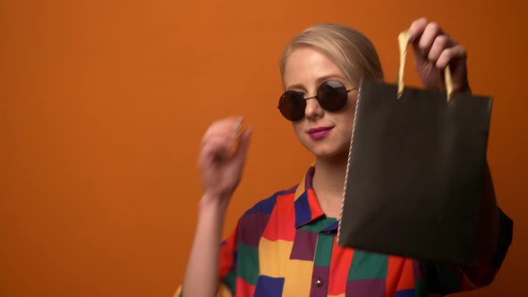 Style blonde in 90s shirt with shopping bag