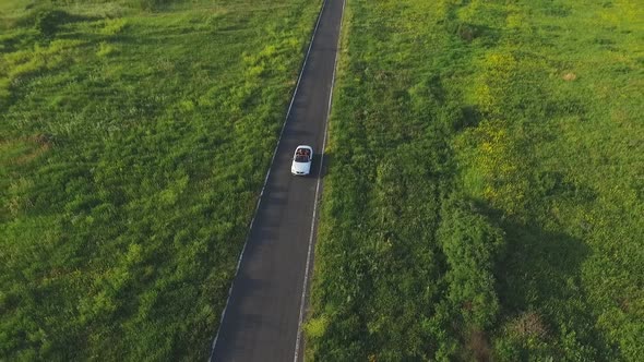 Aerial Shot of White Convertible Car Riding Through Empty Rural Road