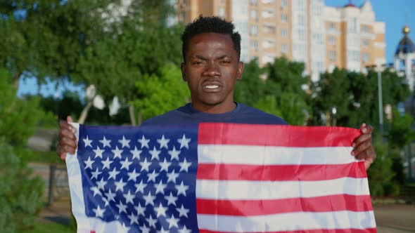 Portrait AfroAmerican Man Holding American Flag Looks Camera Says USA in Summer