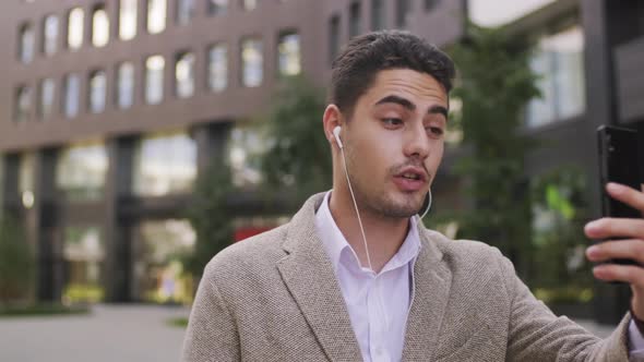  Handsome Businessman Talking on Video Call and Walking