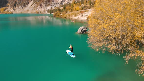 Man Is Paddling on Sup Board in the Mountain Lake