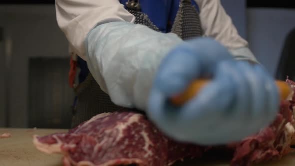 Butcher Cuts Raw Meat with Knife