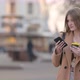 young attractive Woman in a warm coat with a paper cup of coffee or tea on City Street - VideoHive Item for Sale