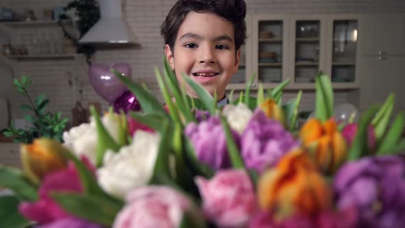 Portrait of Smiling Boy with Bouquet of Flowers