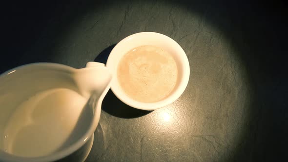 Adding milk in coffee, center light