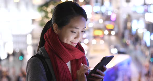 Woman use of mobile phone in city over traffic road background