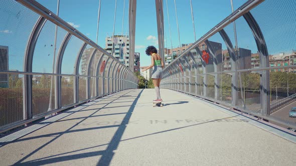 Beautiful young woman cruising around the city with her longboard.