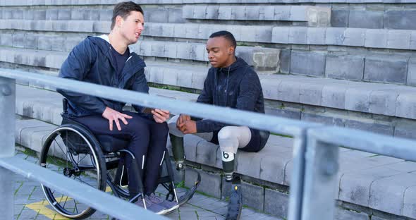 Two disabled athletics discussing over digital tablet 4k