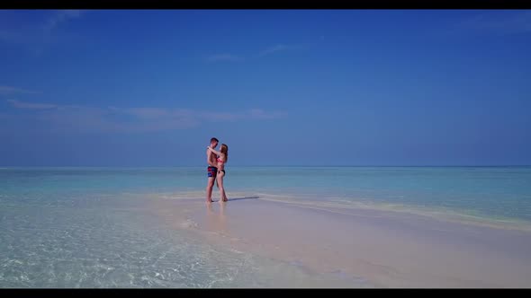 Boy and girl posing on tropical coast beach vacation by blue water and white sand background of the 
