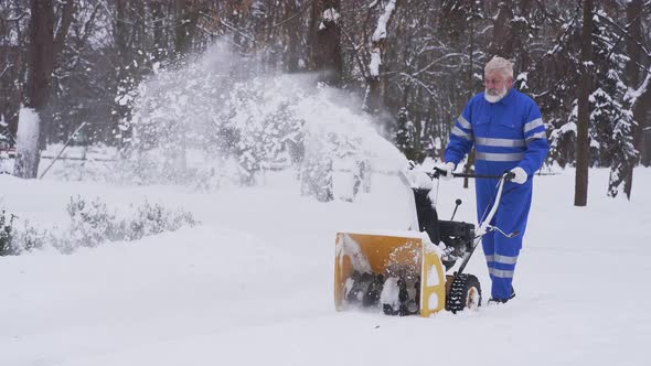 Senior Cleaner Using Snow Removal Machine.