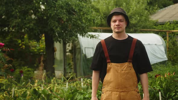 A Young Farmer Holds a Basket of Fresh Juicy Yellow Apricots in His Hands in His Garden