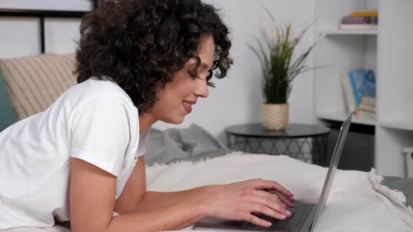 Smiling Hispanic Curly Woman Student Study Uses Laptop Distance Education