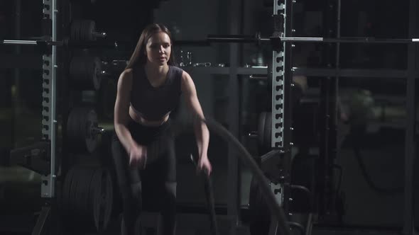 Healthy Lifestyle Female Performs Exercises with Battle Ropes Endurance Training in the Gym