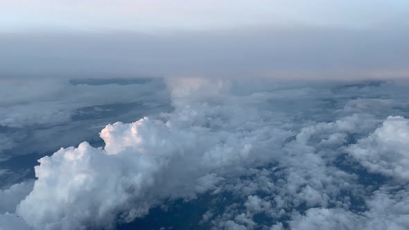 COCKPIT VIEW, DAWN- High altitude cruising over cumulonimbus and altocumulus clouds