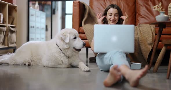 Woman with a Dog and Laptop at Home