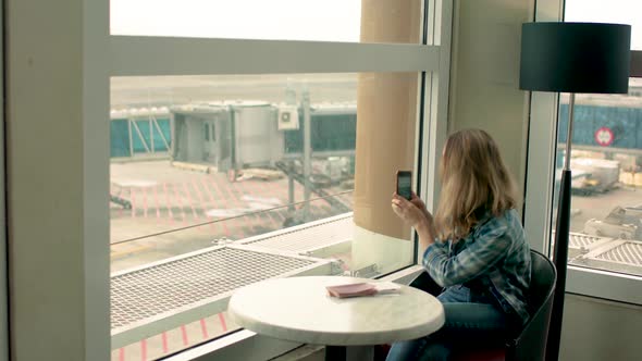 Girl waiting fly in airport and making selfie