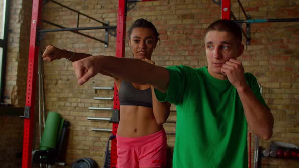 Motivated African American Female Fighter Training Jab with Boxing Trainer