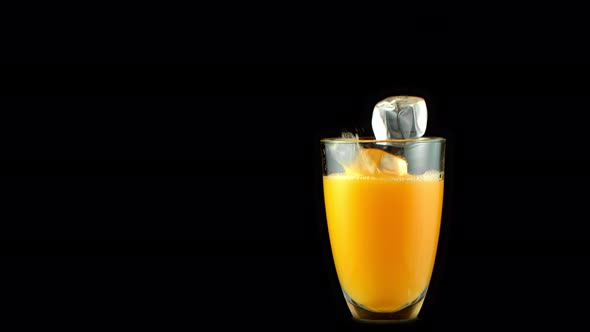 Super Slow Motion Shot of Ice Cubes Falling Into Glass of Orange Juice at 1000 Fps