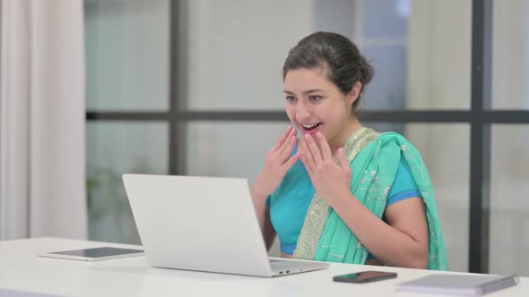 Indian Woman Celebrating Success While Using Laptop in Office