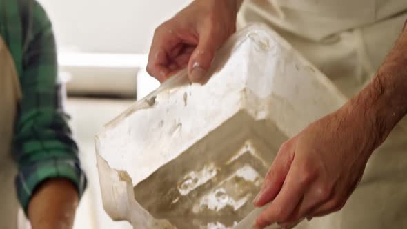 Male potter pouring water